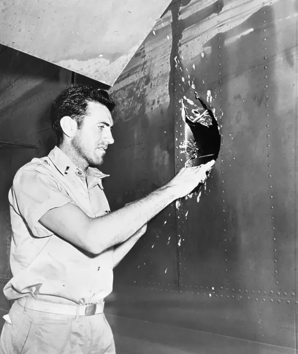Framed Print : Lt. Lou Zamperini examining hole in airplane