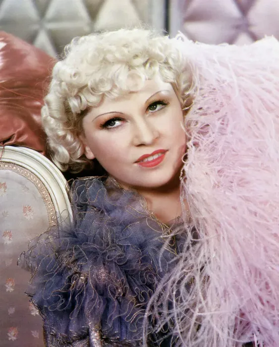 Framed Print : Mae West. Close-up of actress Mae West. She is reclining in a pink boa. Undated photograph