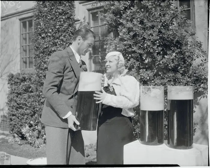 Framed Print : Mae West and Gary Cooper with Large Containers of Beer