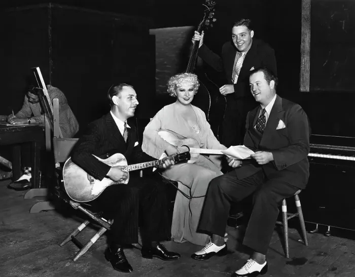Framed Print : Mae West Sitting with Guitar and Musicians Framed Print : Mae West Sitting with Guitar and Musicians