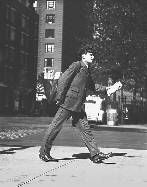 Mailman holding letters walking on street, (B&W)