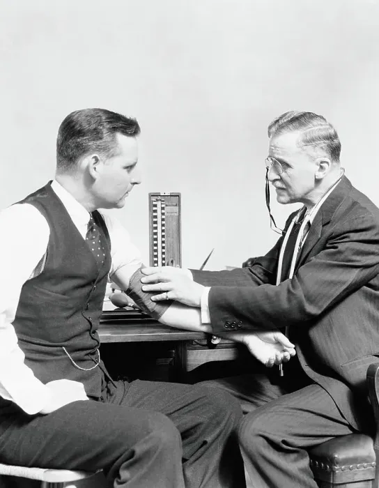 Framed Print : Male doctor taking blood pressure of male patient Framed Print : Male doctor taking blood pressure of male patient