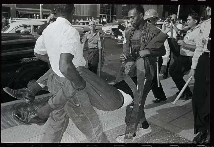 Framed Print : Man Being Carried by Two Officers Framed Print : Man Being Carried by Two Officers