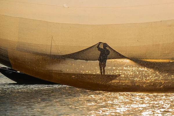 A man checking golden net in Hoi An river, Quang Nam province, Vietnam
