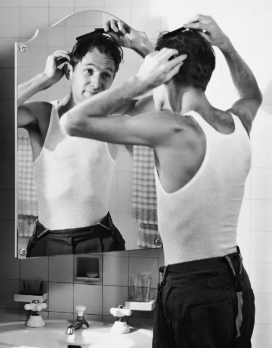 Framed Print : Man combing hair in bathroom