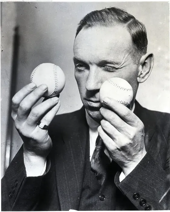 Framed Print : Man Comparing Two Baseballs Framed Print : Man Comparing Two Baseballs