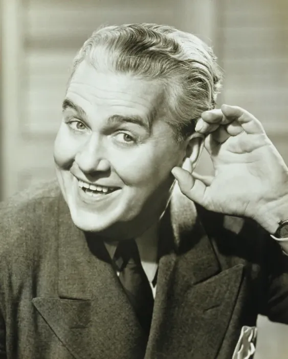 Framed Print : Man cupping hand to ear, posing, smiling, (B&W), portrait