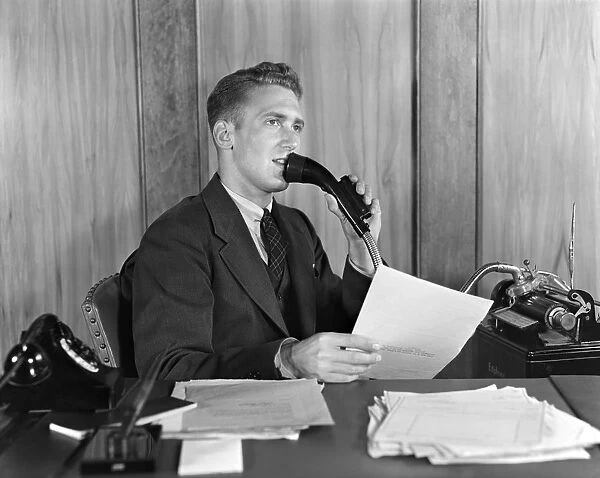 Man at desk talking into Dictaphone