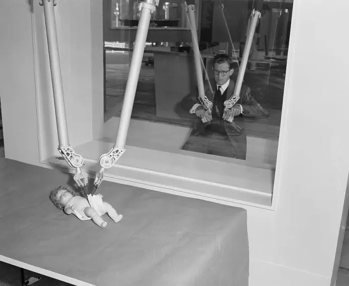 Framed Print : Man Diapering Baby Doll with Mechanical Hands Framed Print : Man Diapering Baby Doll with Mechanical Hands
