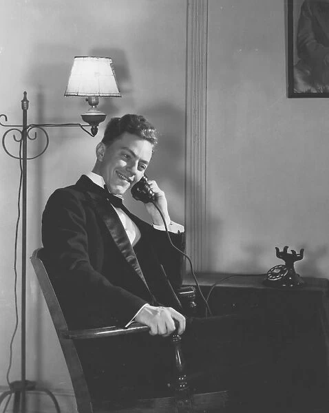 Man in Dinner Suit Sitting Indoors, Talking on Telephone