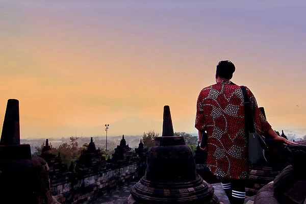 Man in dress overlooking mountains at Borobudur