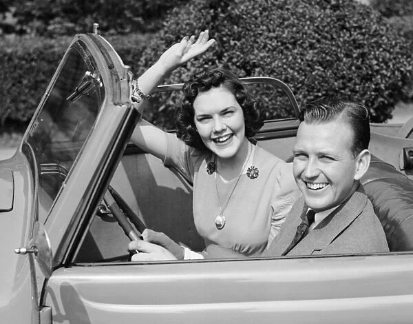 Man driving car and woman waving