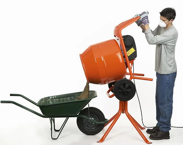 Man emptying contents of cement mixer into a wheelbarrow