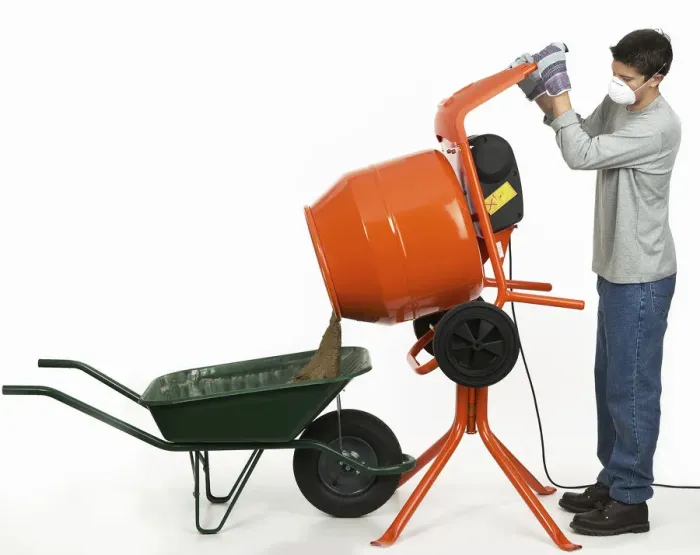 Framed Print : Man emptying contents of cement mixer into a wheelbarrow Framed Print : Man emptying contents of cement mixer into a wheelbarrow