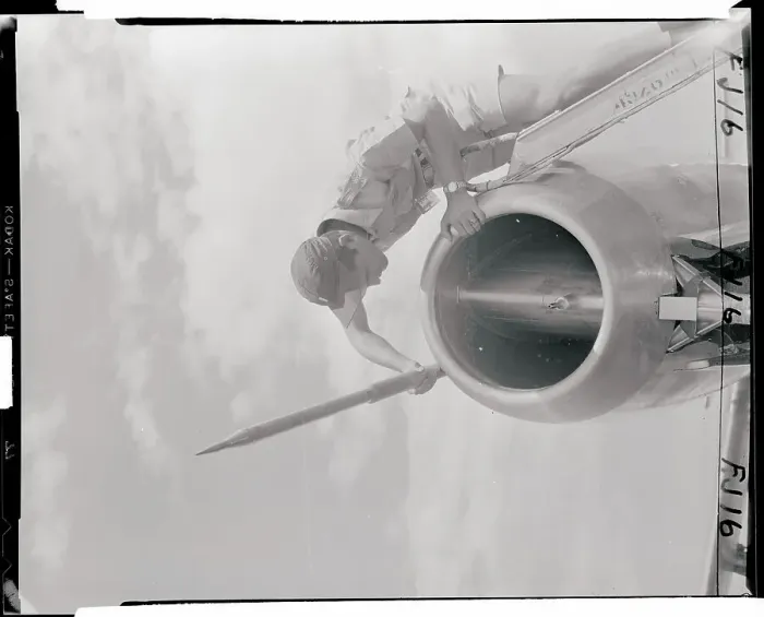 Framed Print : Man Examining a Tube on the Nose of a Jet Framed Print : Man Examining a Tube on the Nose of a Jet