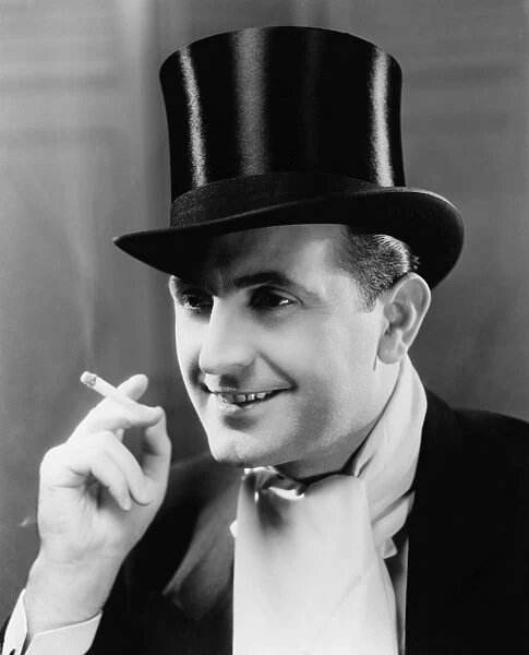 Man in top hat smoking cigarette, (B&W), portrait