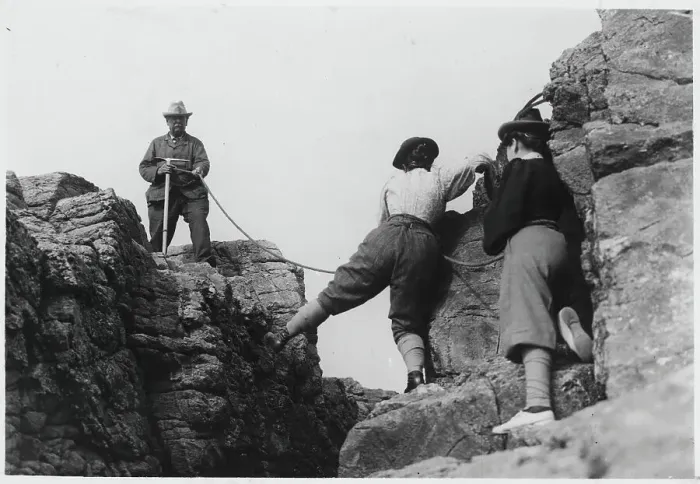 Framed Print : Man Helping Women on Mountainous Rock Framed Print : Man Helping Women on Mountainous Rock