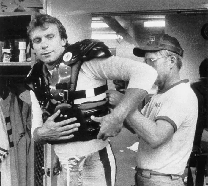 Framed Print : Man Helps Joe Montana With Rib Cage Guard Framed Print : Man Helps Joe Montana With Rib Cage Guard