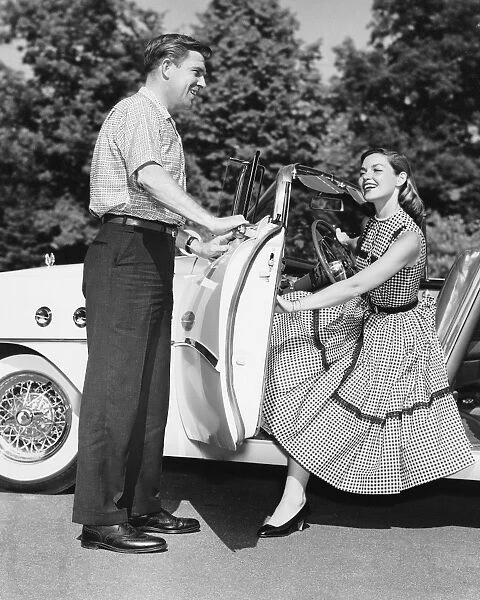 Man holding car door open for woman