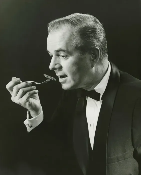 Framed Print : Man holding fork, taking bite in studio, (B&W), portrait Framed Print : Man holding fork, taking bite in studio, (B&W), portrait