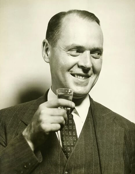 Man holding glass with spirit, (B&W), close-up