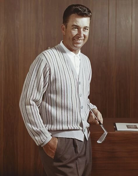 Man holding golf club, smiling