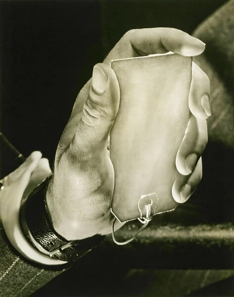 Man holding key label, close-up of hand, (B&W)