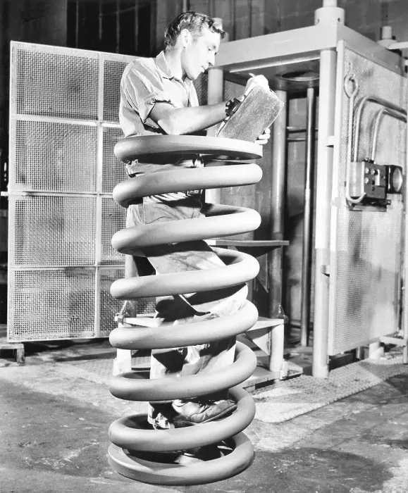 Framed Print : Man Inspecting Giant Spring Coil Framed Print : Man Inspecting Giant Spring Coil