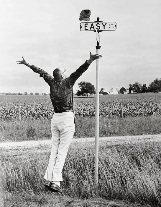 Framed Print : Man Jumping for Joy Near Sign for Easy Street Framed Print : Man Jumping for Joy Near Sign for Easy Street