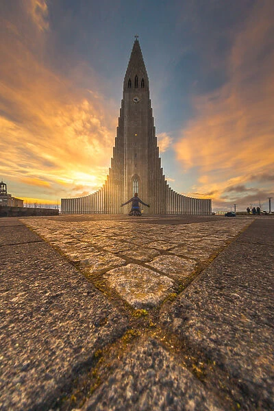 a man kneel down in front of Hallgrimskirkja, Iceland