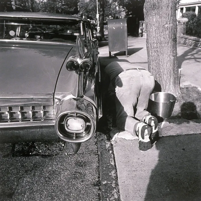 Framed Print : Man kneeling on ground and washing car Framed Print : Man kneeling on ground and washing car