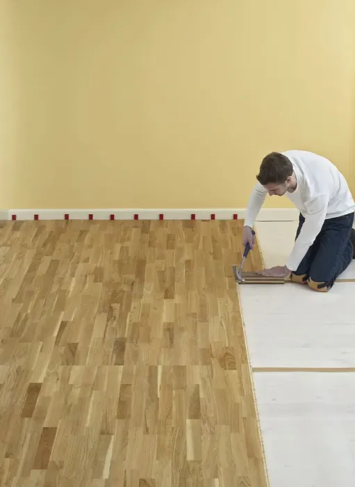 Framed Print : Man kneeling and holding hammer over floorboards