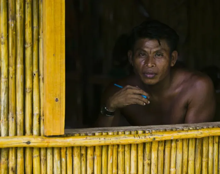 Framed Print : Man looking out window of bamboo hut, portrait Framed Print : Man looking out window of bamboo hut, portrait