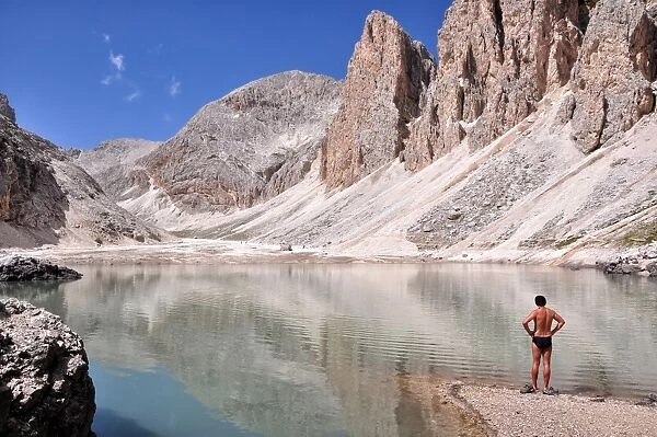 A man looks at the Lago di Antermoia, Rosengarten group, Dolomites, Trentino-Alto Adige  /  South Tyrol, Italy