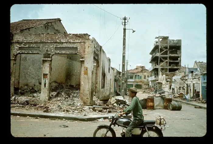 Framed Print : Man on Moped Rides Past Bombed Building Framed Print : Man on Moped Rides Past Bombed Building