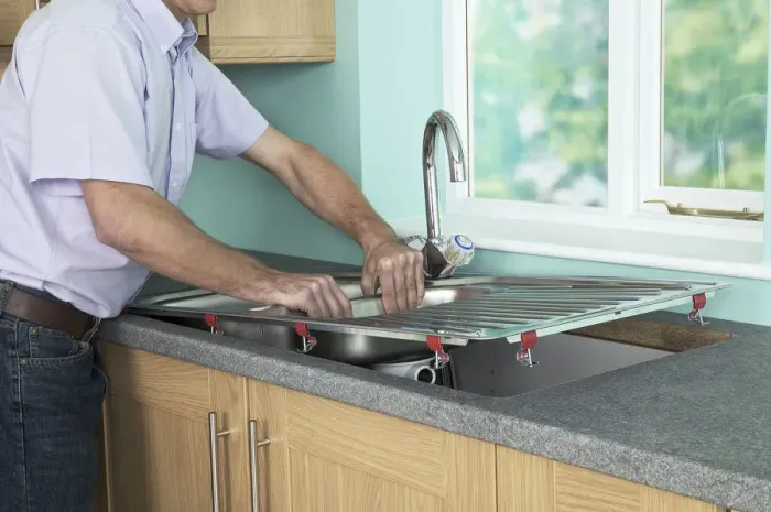 Framed Print : Man placing a new sink in to position in a worktop