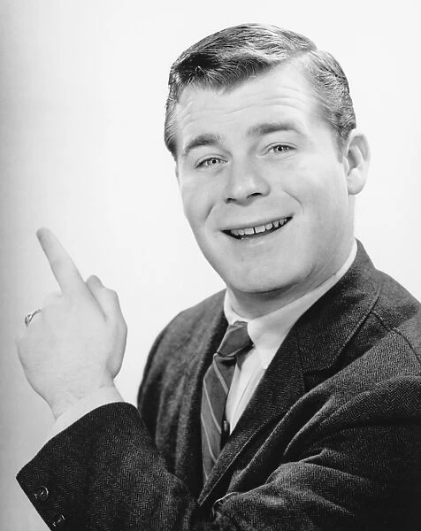 Man pointing with forefinger in studio, (B&W), close-up, portrait