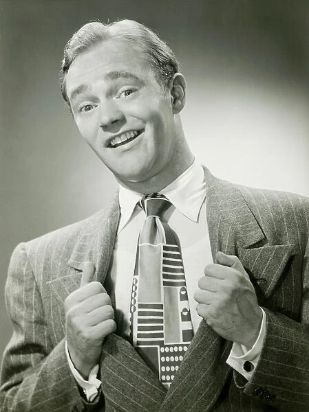 Man pulling sides of jacket apart to reveal tie, portrait