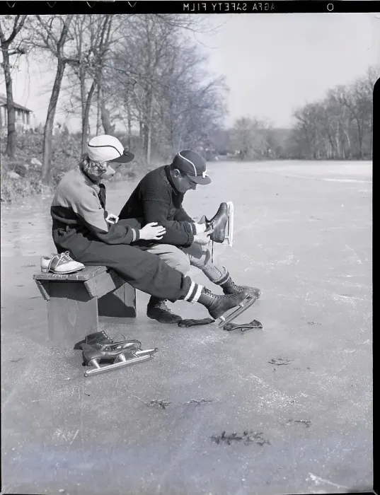 Framed Print : Man Puts Ice Skates On Woman At Rink Framed Print : Man Puts Ice Skates On Woman At Rink