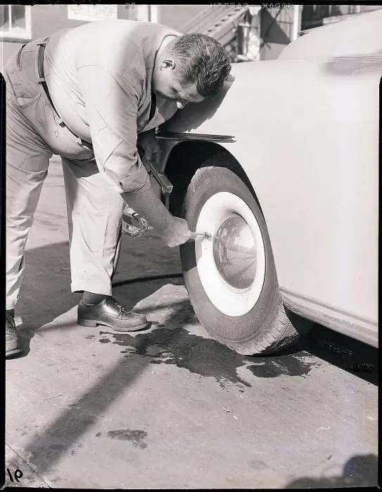 Framed Print : Man Putting Air in Automobile Tire Framed Print : Man Putting Air in Automobile Tire