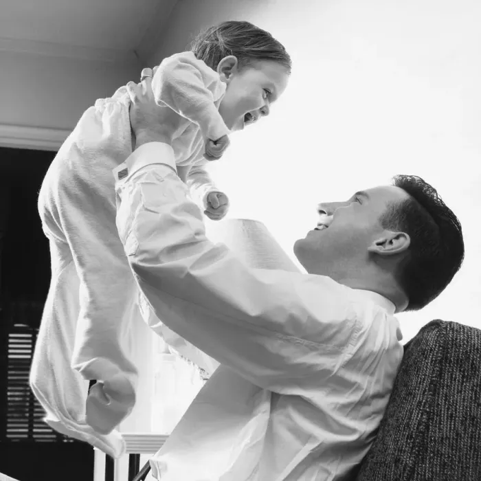 Framed Print : Man raising baby over head Framed Print : Man raising baby over head