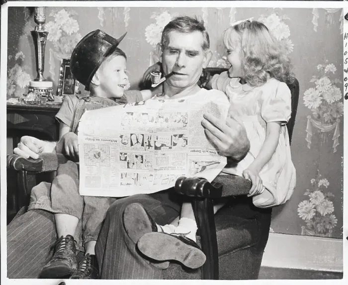 Framed Print : Man Reading Newspaper With Grandchildren Framed Print : Man Reading Newspaper With Grandchildren