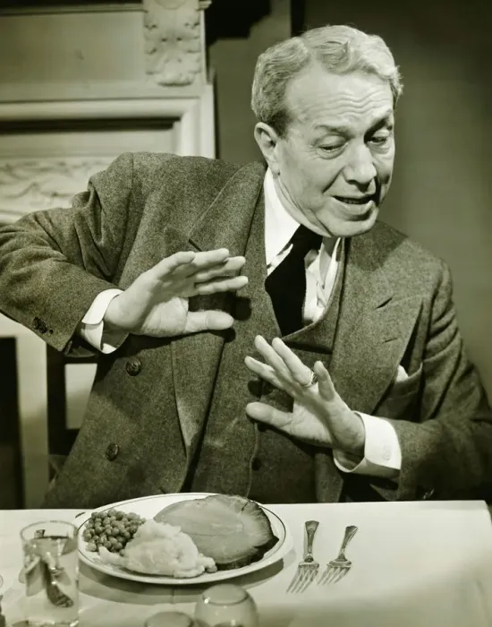 Framed Print : Man refusing to eat dinner in restaurant, (B&W) Framed Print : Man refusing to eat dinner in restaurant, (B&W)