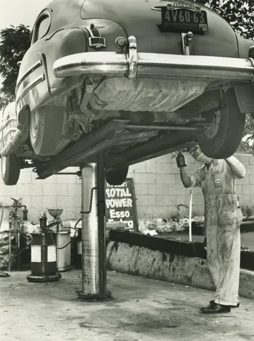 Framed Print : Man repairing uplifted car, (B&W), low section Framed Print : Man repairing uplifted car, (B&W), low section