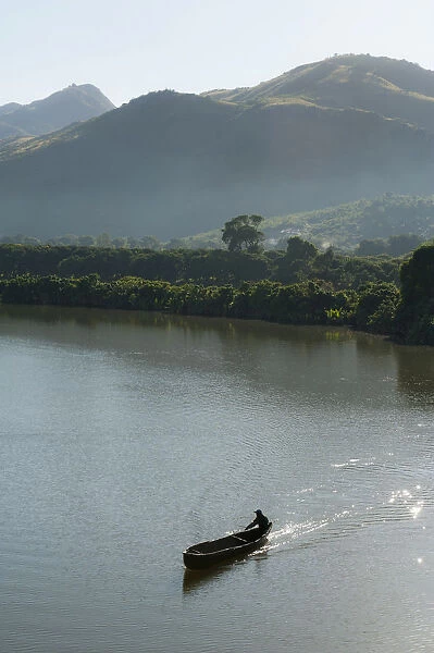 Man in a rowing boat, dug out canoe on a river in the morning, near Fort-Dauphin or Tolagnaro, Madagascar