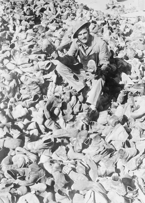 Framed Print : Man Sitting Amidst Pile of Military Boots Framed Print : Man Sitting Amidst Pile of Military Boots