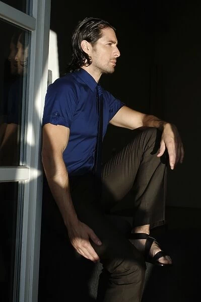 Man sitting by a window, fashion shoot