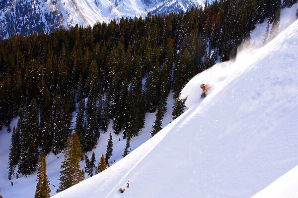 Man skiing in deep powder, side view