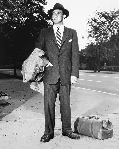 Man in full suit standing on sidewalk, (B&W), (Portrait)