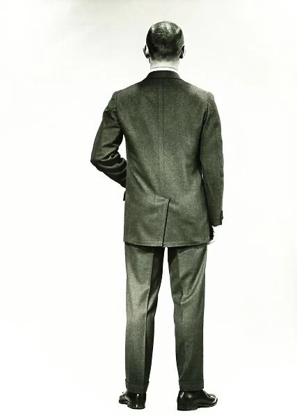 Man in full suit standing in studio, (Rear view), (B&W)